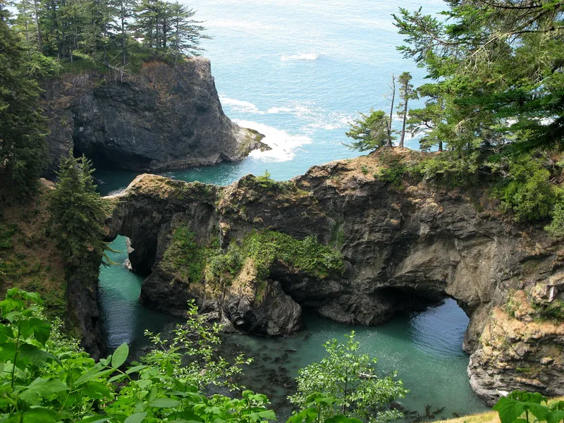 Vegetated rock arches above the cove at Natural Bridges on the Oregon coast