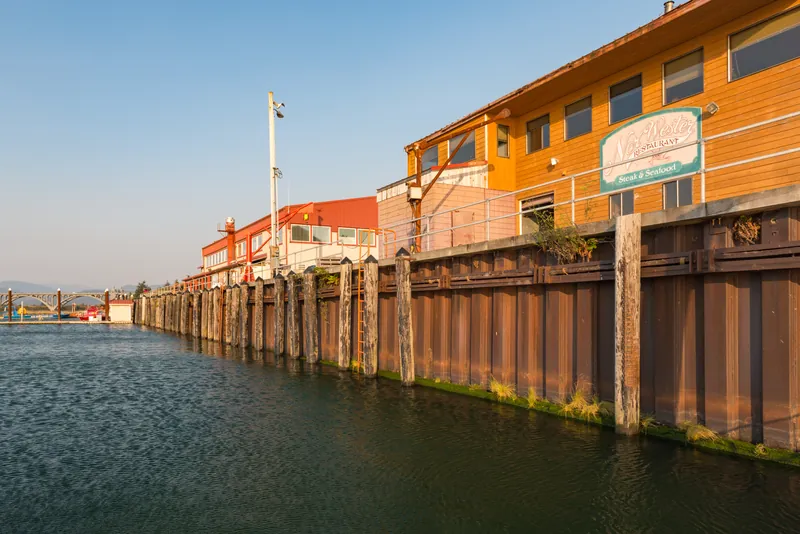 Harborfront businesses reflected in the water at Gold Beach Harbor