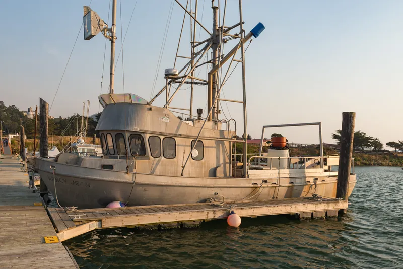 Boat with masts and rigging moored at a dock in Gold Beach Harbor